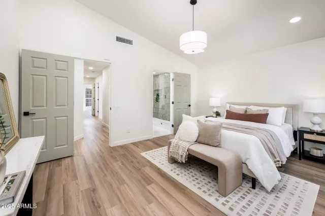 a spacious bedroom with a bed and wooden floor