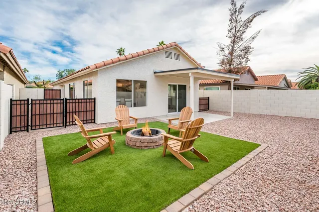 a view of a house with backyard and sitting area