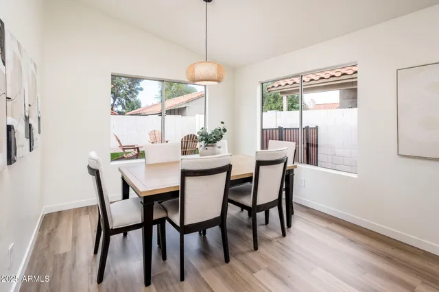 a dining room with furniture a chandelier and wooden floor