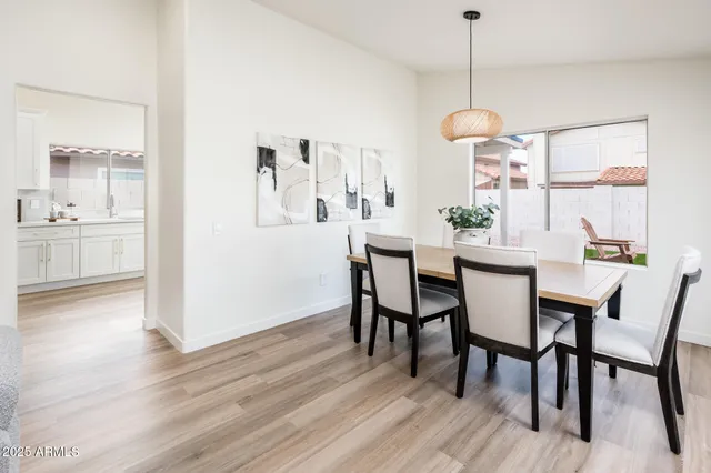 a dining room with furniture a chandelier and wooden floor