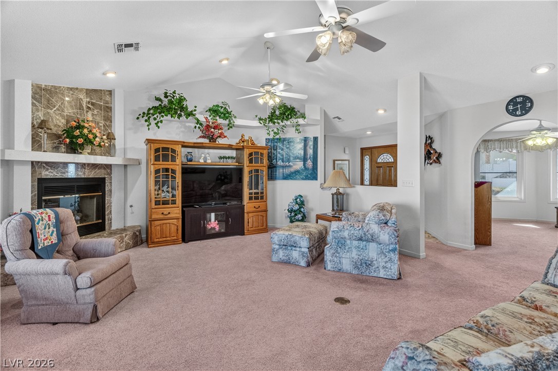 2055 Cholla Way Laughlin, NV 89029 - Photo 7 of 87 A spacious living area with vaulted ceilings features a grand fireplace and cozy carpet underfoot.