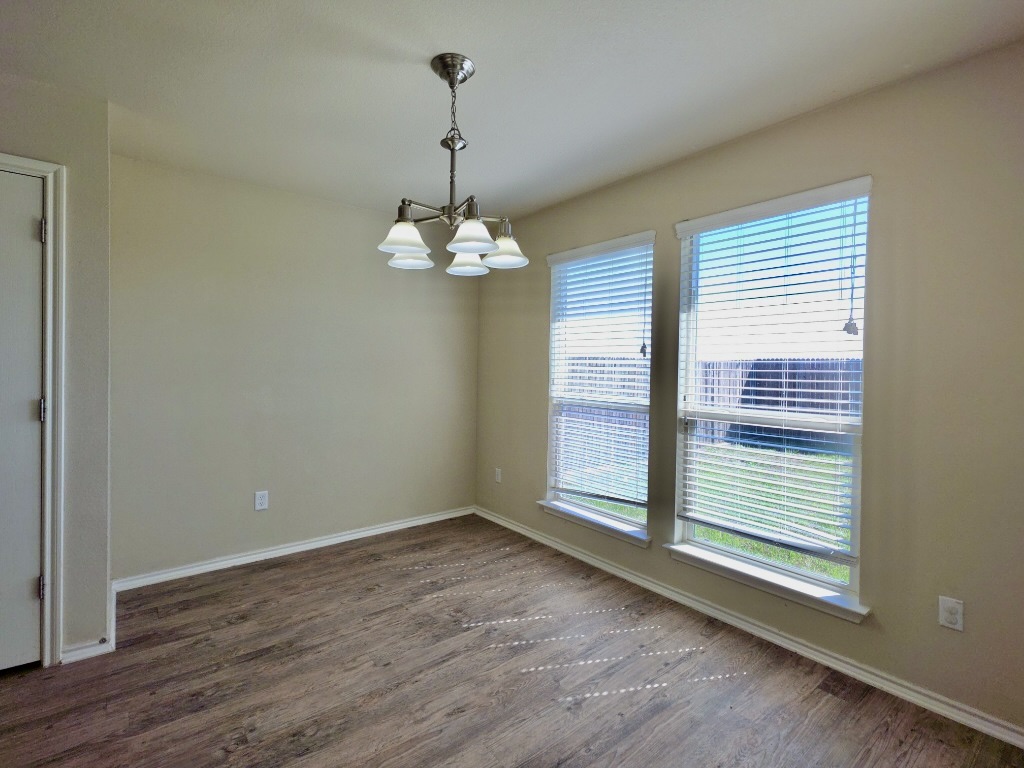 809 Yabers Court Austin, TX 78725 - Photo 11 of 29 Spare room with hanging lights and dark wood-type flooring