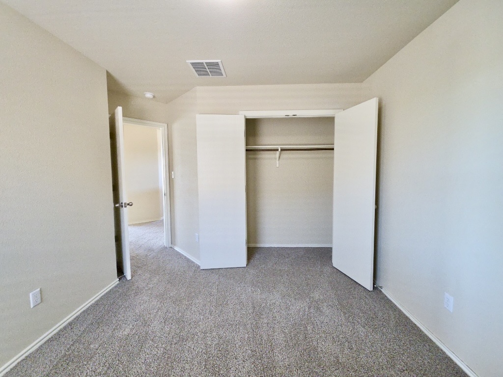 809 Yabers Court Austin, TX 78725 - Photo 23 of 29 Bedroom with light colored carpet and a closet