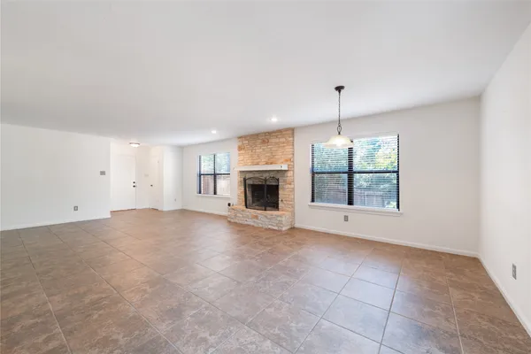 an empty room with fireplace and windows