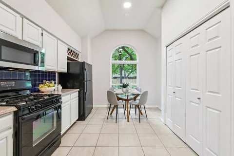 a kitchen with stainless steel appliances granite countertop a stove a sink and a microwave