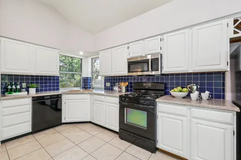 a kitchen with stainless steel appliances granite countertop a stove sink and cabinets