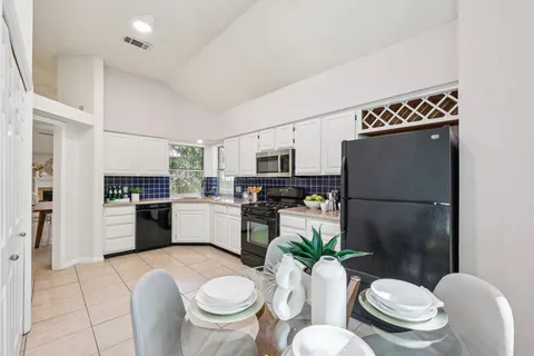 a kitchen with a refrigerator and a stove top oven