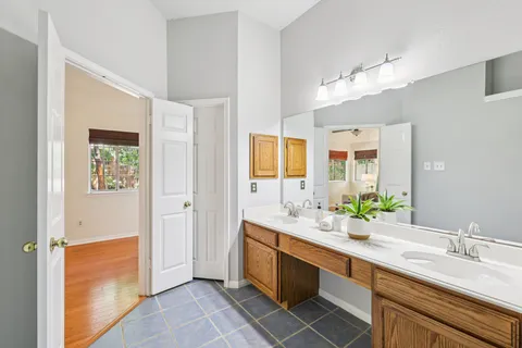 a spacious bathroom with a double vanity sink a mirror and a shower
