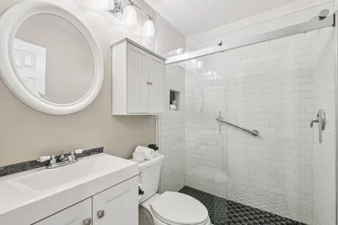 a bathroom with a sink a toilet and a mirror