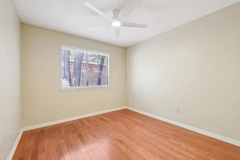 an empty room with a window and a ceiling fan