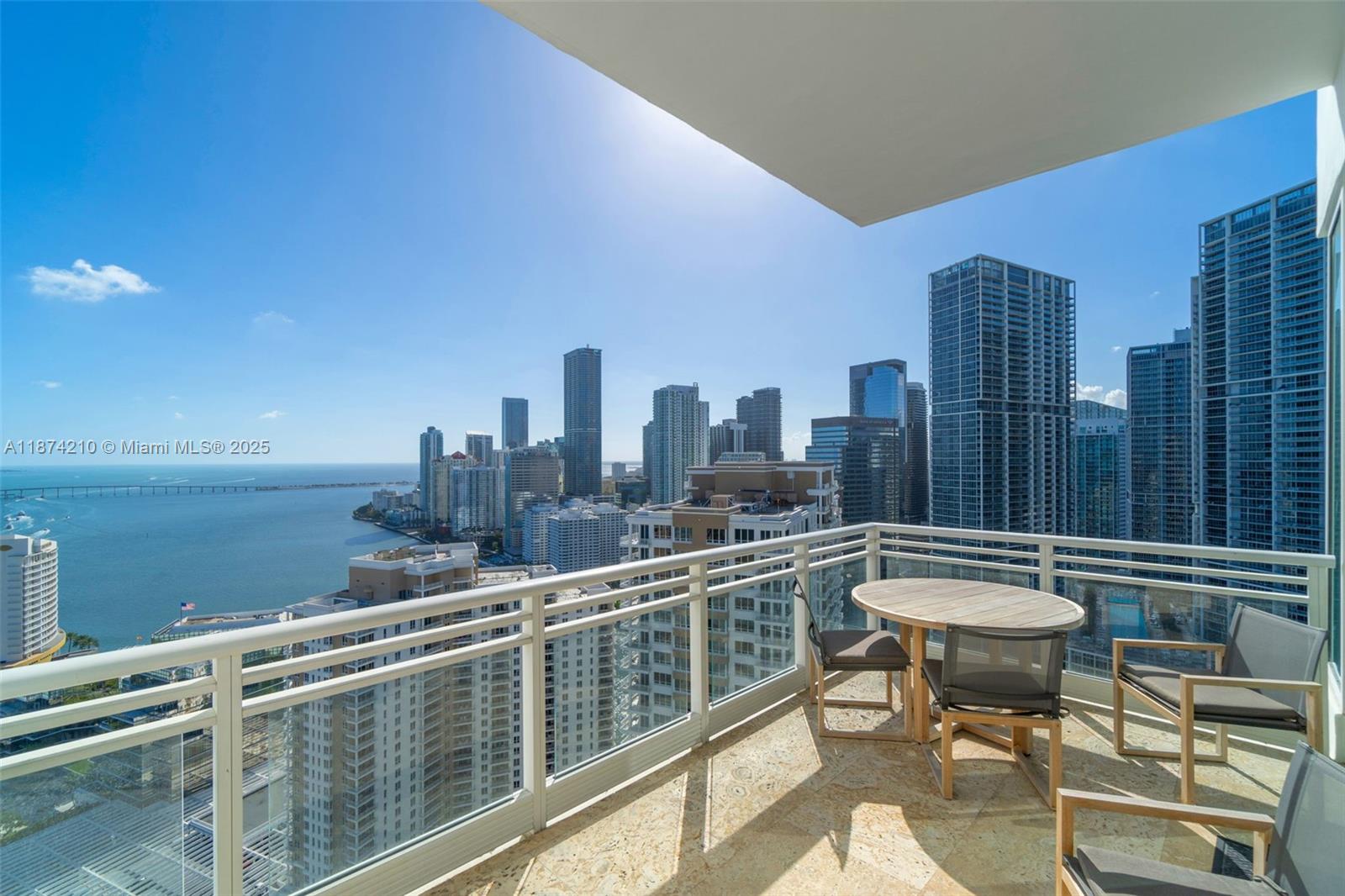900 Brickell Key Boulevard, Unit 2904 Miami, FL 33131 - Photo 14 of 21 a roof deck with table and chairs and wooden floor