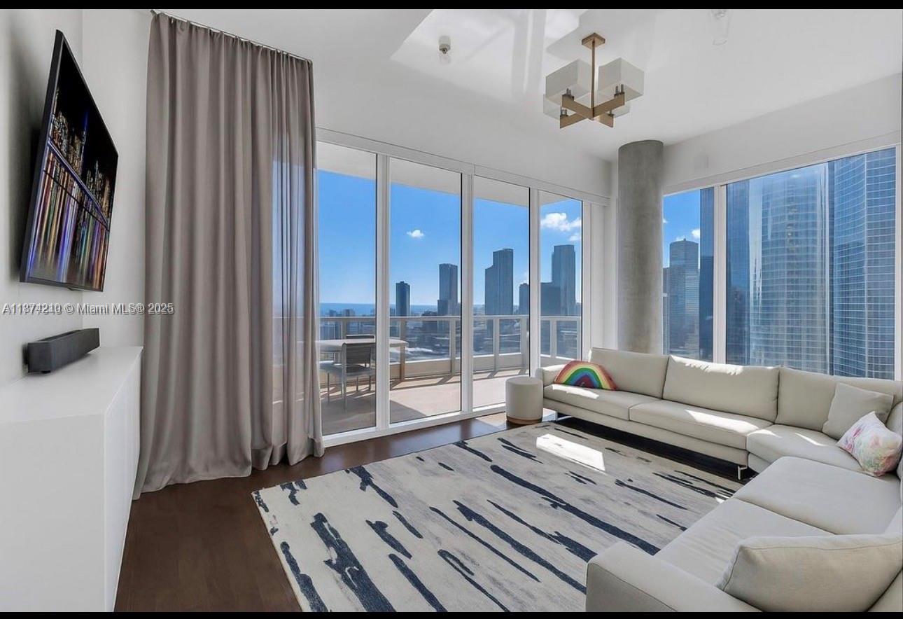 900 Brickell Key Boulevard, Unit 2904 Miami, FL 33131 - Photo 2 of 21 a living room with furniture and a floor to ceiling window