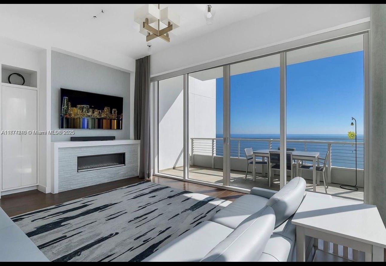 900 Brickell Key Boulevard, Unit 2904 Miami, FL 33131 - Photo 4 of 21 a living room with furniture a fireplace and a flat screen tv