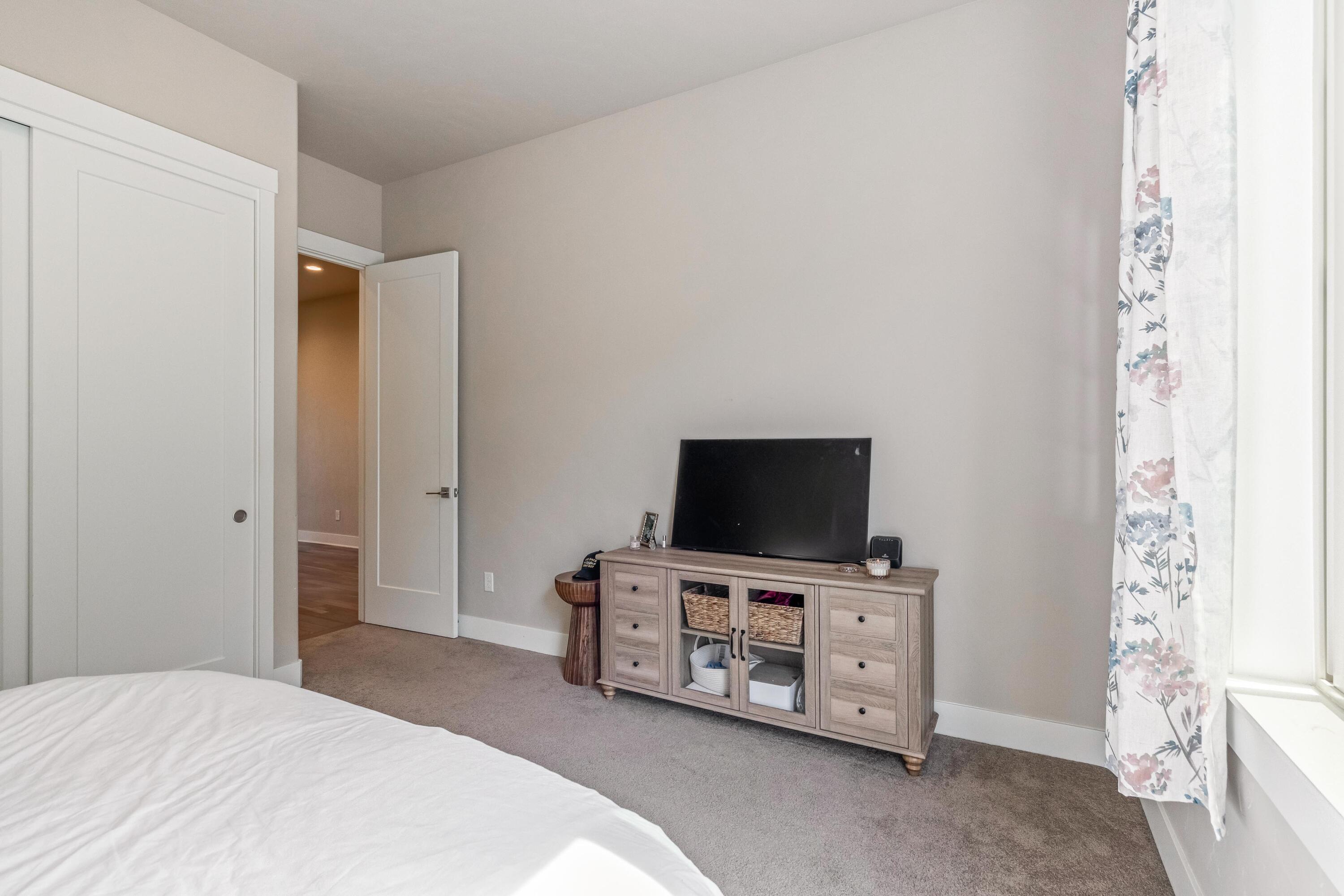 2375 Northwest Majestic Ridge Drive Bend, OR 97703 - Photo 23 of 28 a bedroom with a flat screen tv on the dresser and a flat screen tv