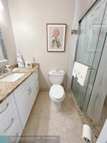 a spacious bathroom with a granite countertop toilet a sink and a mirror