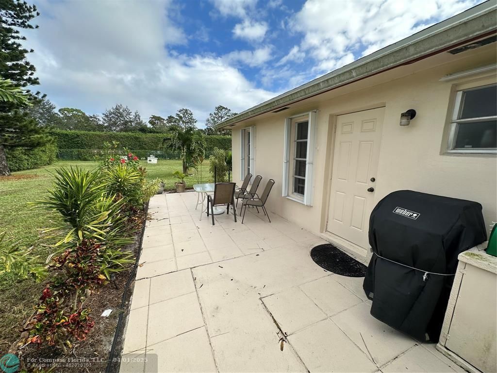 4525 Northwest 3rd Court Delray Beach, FL 33445 - Photo 23 of 23 a backyard of a house with table and chairs