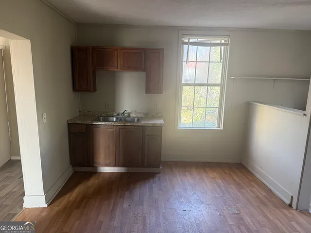 an empty room with wooden floor and cabinets