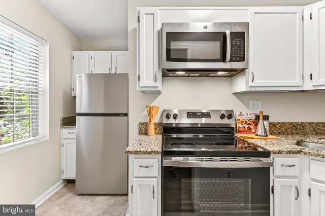 a kitchen with stainless steel appliances granite countertop a stove and a refrigerator