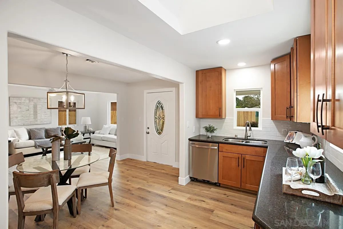 9350 Rapture Lane Santee, CA 92071 - Photo 14 of 30 a dining hall with stainless steel appliances kitchen island granite countertop wooden floor a dining table and chairs