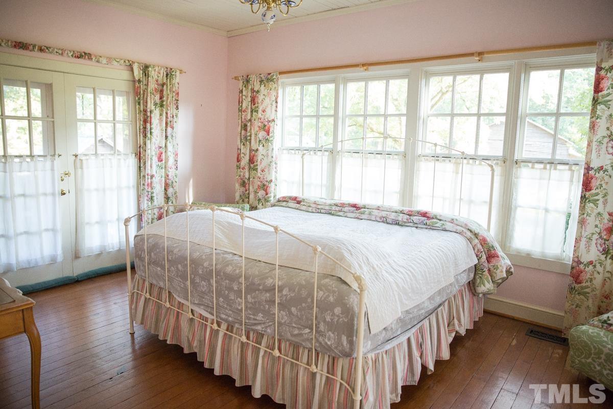 395 Cecil Road Wendell, NC 27591 - Photo 11 of 29 a bedroom with a bed a large window and wooden floor