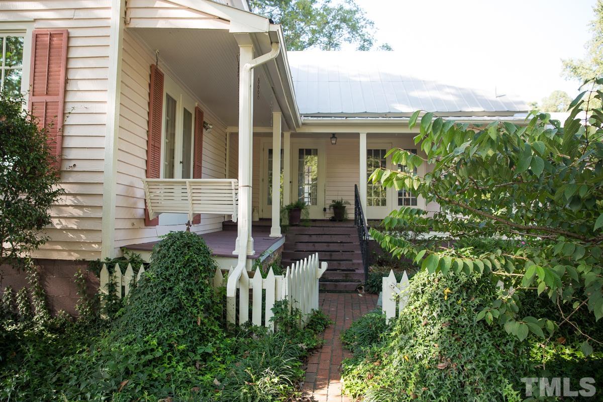 395 Cecil Road Wendell, NC 27591 - Photo 5 of 29 a view of a house with potted plants and a bench