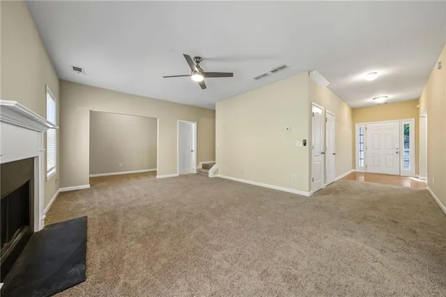 an empty room with a fireplace and fan