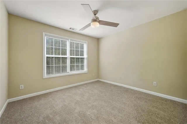 an empty room with a ceiling fan and window