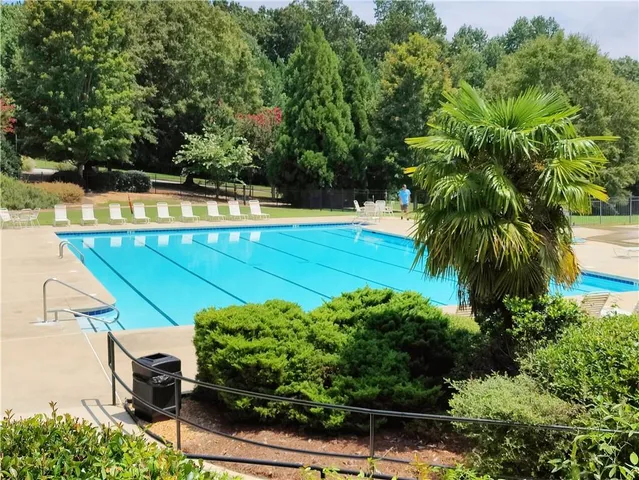 an outdoor space with swimming pool and green space