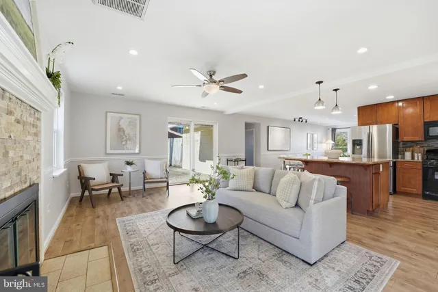 a living room with furniture kitchen view and a large window