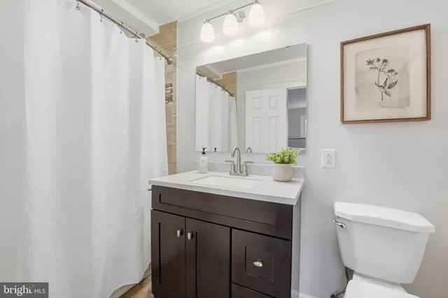 a bathroom with a toilet a sink and a mirror