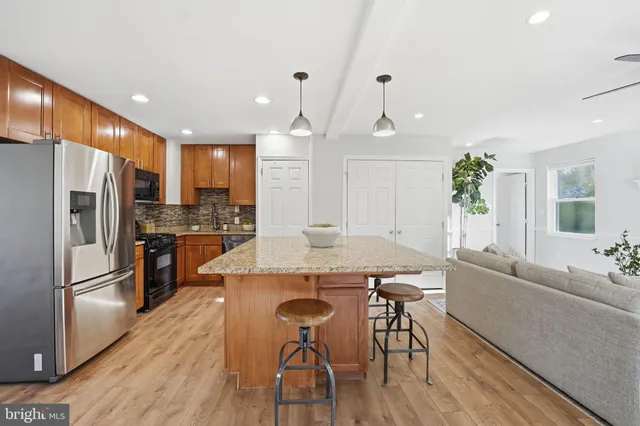 a large kitchen with cabinets wooden floor and stainless steel appliances