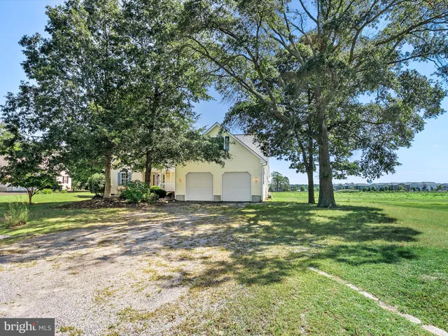 a big white house with a big yard and large trees