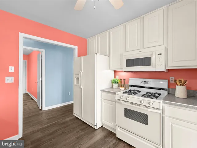 a kitchen with granite countertop a white stove and refrigerator