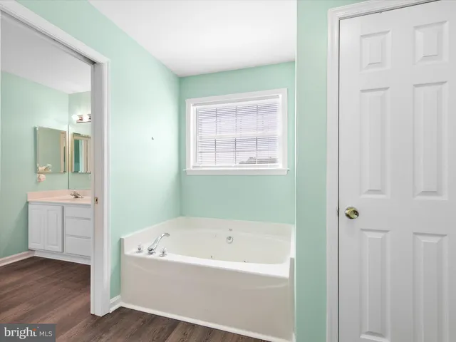 a white bath tub sitting next to a bathroom sink