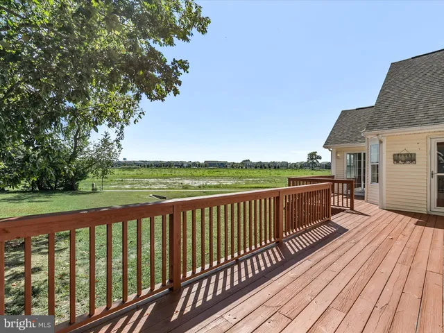 a view of a wooden house with a yard and potted plants