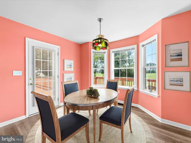 a dining room with furniture a chandelier and wooden floor