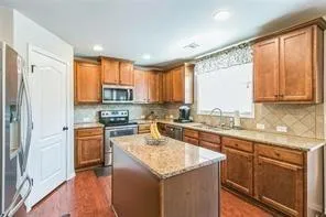 a kitchen with a refrigerator a sink a stove a microwave and cabinets