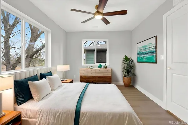 a bedroom with a large bed and a chandelier fan