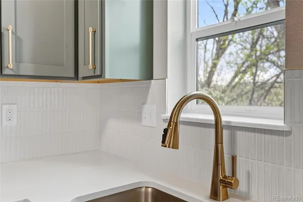 a close view of a faucet a sink and a window