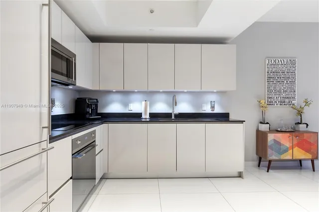 a kitchen with stainless steel appliances granite countertop a stove a sink and a microwave