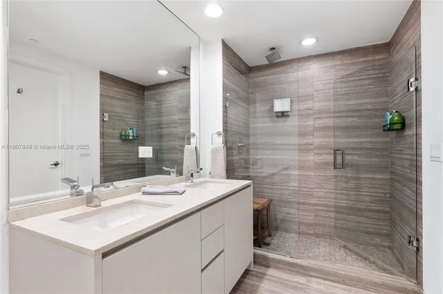 a bathroom with a sink shower and a mirror