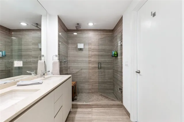 a bathroom with a sink shower and a mirror