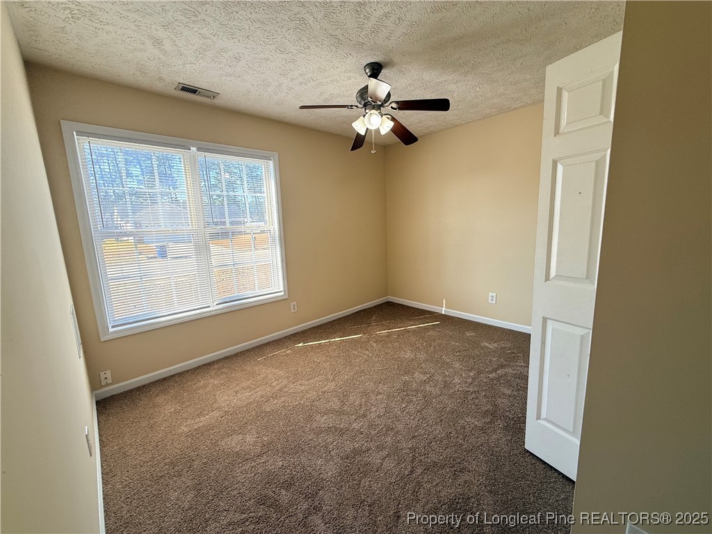 203 Cypress Drive Raeford, NC 28376 - Photo 11 of 21 an empty room with windows and fan