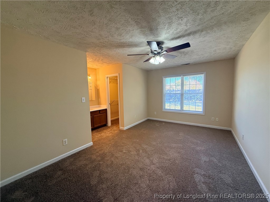 203 Cypress Drive Raeford, NC 28376 - Photo 13 of 21 an empty room with chandelier fan and windows