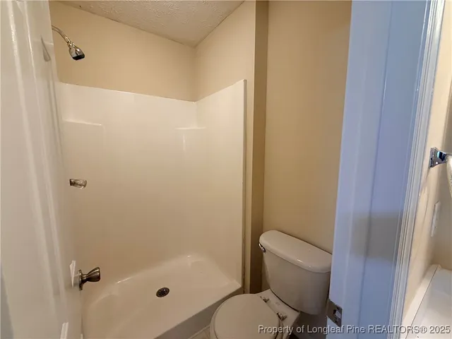 a bathroom with a toilet and a shower