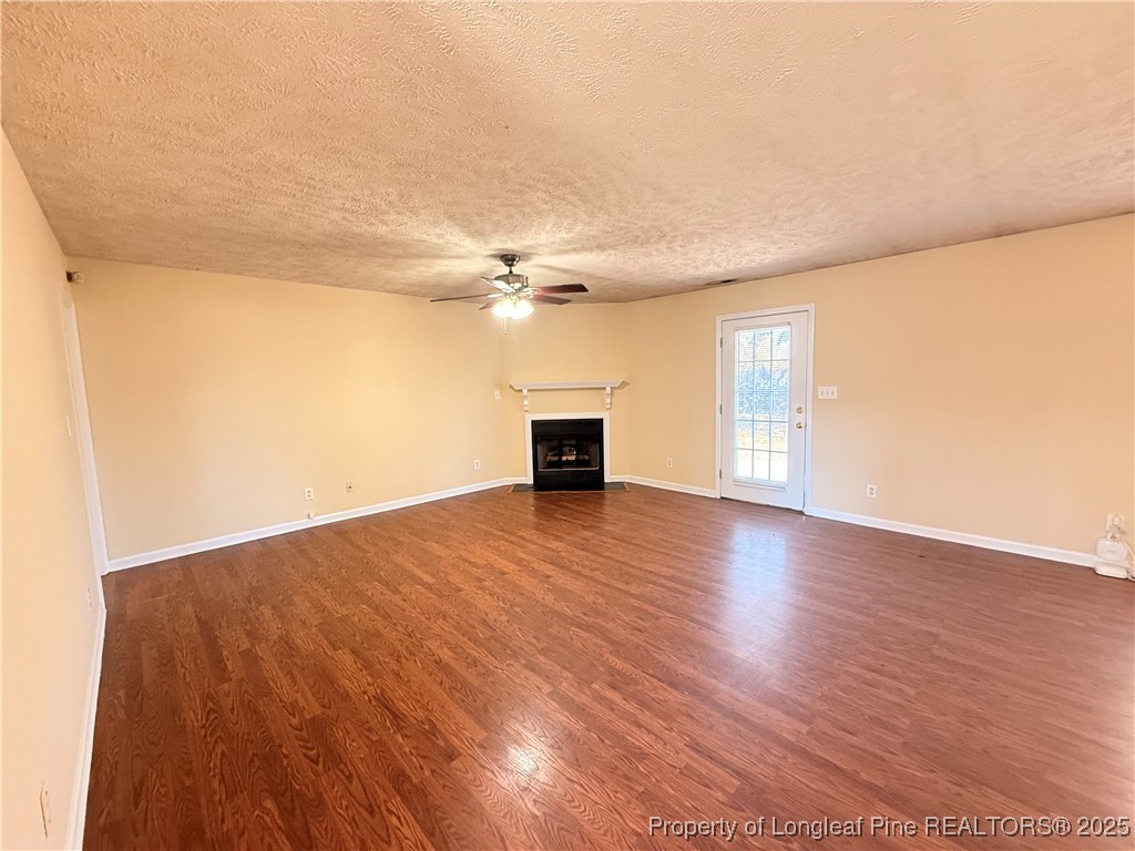 203 Cypress Drive Raeford, NC 28376 - Photo 3 of 21 an empty room with wooden floor and windows