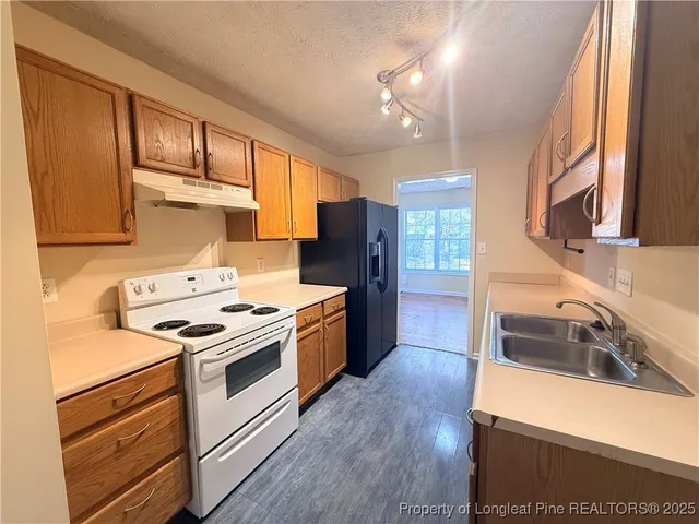 a kitchen with a stove sink and cabinets