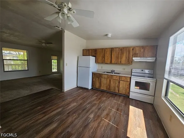 a kitchen with granite countertop a stove cabinets and wooden floor