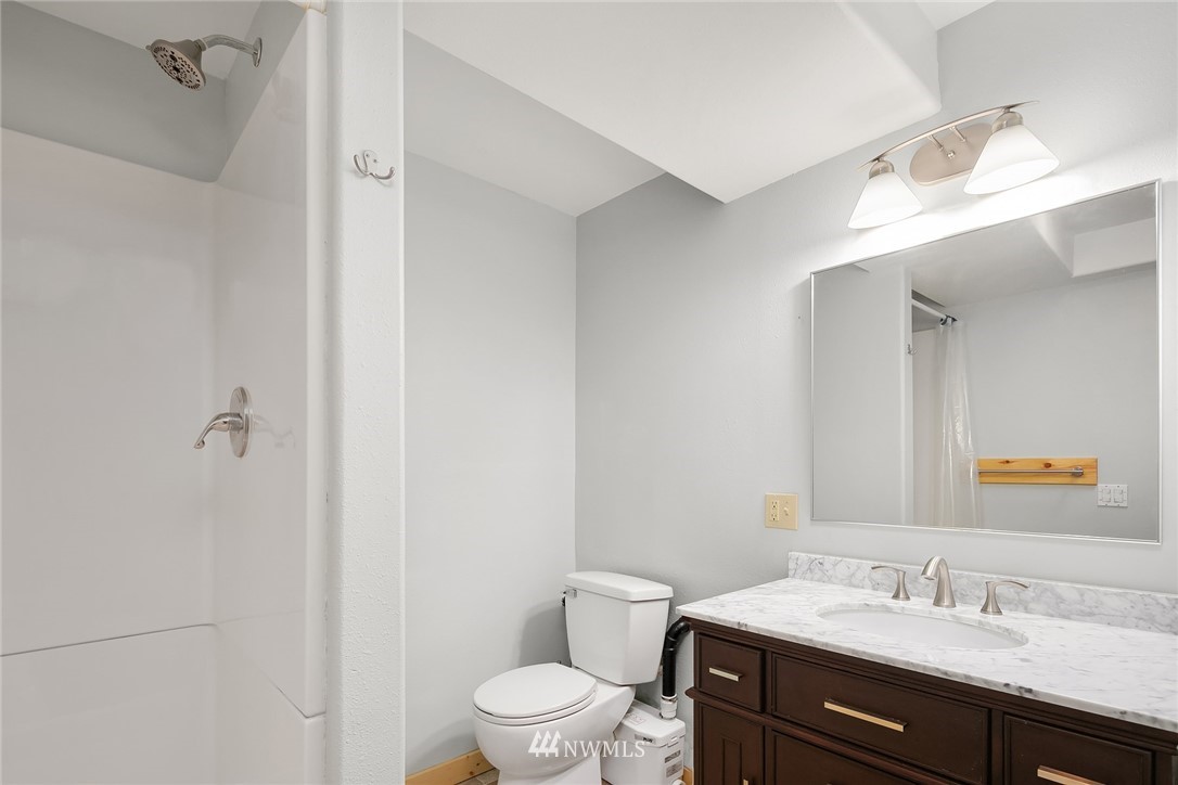 4730 Spring Street Bellingham, WA 98229 - Photo 25 of 30 a bathroom with a sink a toilet a mirror and vanity