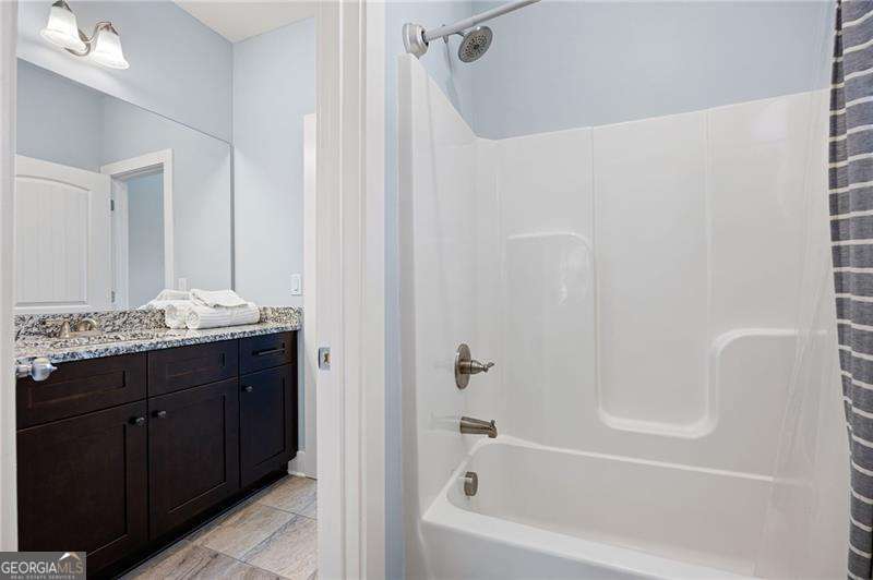 61 Roberson Drive White, GA 30184 - Photo 40 of 46 a bathroom with a granite countertop sink a mirror and a bathtub